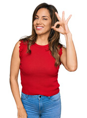 Young hispanic woman wearing casual clothes smiling positive doing ok sign with hand and fingers. successful expression.