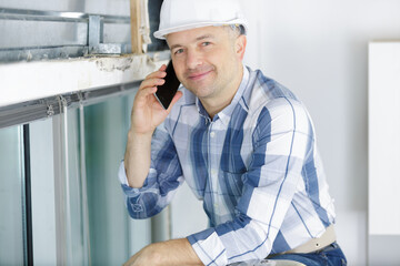 middle-aged male builder ising a mobile telephone