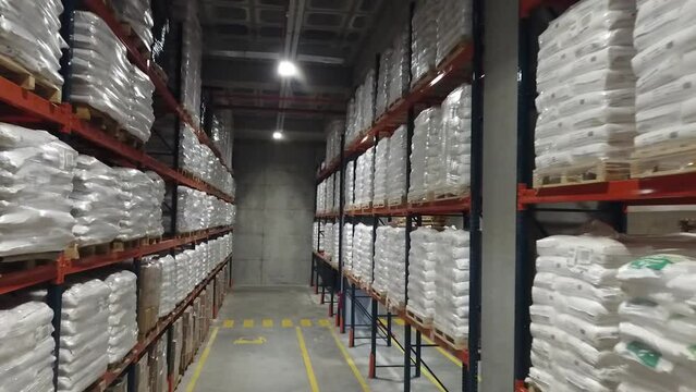 4K Aerial view of chemical warehouse. Wide angle shooting of warehouse and shelves. Symmetrical view of placed up palleted goods. Forest of shelves. Stock video.  