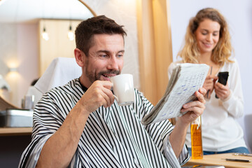 happy guy drinking beverage at beauty salon