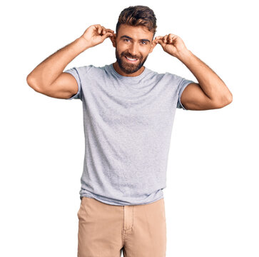 Young hispanic man wearing casual clothes smiling pulling ears with fingers, funny gesture. audition problem