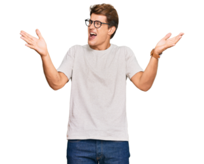 Handsome caucasian man wearing casual clothes and glasses celebrating mad and crazy for success with arms raised and closed eyes screaming excited. winner concept