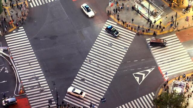 TOKYO - OCT 3rd, 2022: Aerial view of people and traffic crossing the famous Shibuya scramble intersection in Tokyo, Japan in time-lapse