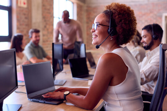 Multi-Cultural Business Team Wearing Headsets Working In Customer Support Centre