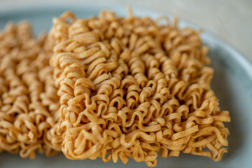 dried Instant noodles on white mulberry paper background. Instant noodles and pasta are wheat flour products call junk convenience food. Chinese and Japanese oriental noodle.