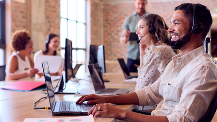 Fototapeta premium Multi-Cultural Business Team Wearing Headsets Working In Customer Support Centre