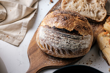 Artisan Batard Sourdough healthy Bread with leaf scoring. Open crumb high hydration Sourdough bread set on white table.