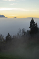 Naklejka na ściany i meble Sunset in the mountains above a sea of fog