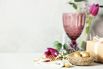 Easter table decorations on light grey background copy space