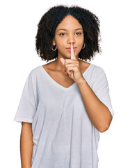 Young african american girl wearing casual clothes asking to be quiet with finger on lips. silence...