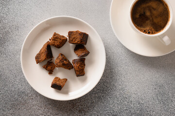 Kithul jaggery and treacle natural sweetener in bowl on gray background. View from above....