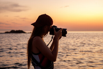 Photographer on the ocean beach during sunset.