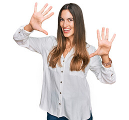 Young beautiful woman wearing casual clothes showing and pointing up with fingers number ten while smiling confident and happy.