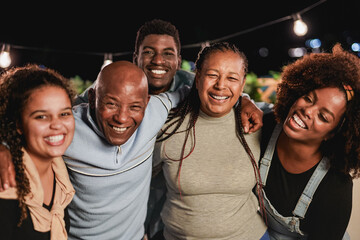 Happy african family celebrating at home patio during night time