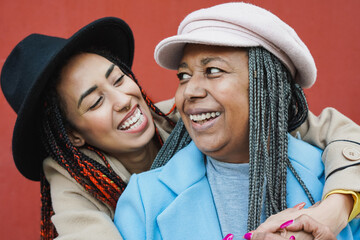 Happy african mother having tender moment with adult daughter during winter time- Family love concept