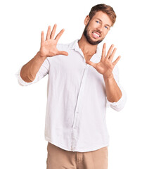 Young caucasian man wearing casual clothes afraid and terrified with fear expression stop gesture with hands, shouting in shock. panic concept.