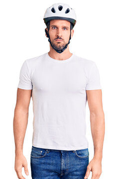 Young handsome man wearing bike helmet depressed and worry for distress, crying angry and afraid. sad expression.