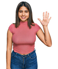Young hispanic girl wearing casual t shirt showing and pointing up with fingers number five while smiling confident and happy.