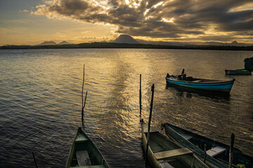 Photographic composition with wooden boats forming diagonal lines that lead the eye to the mountains at sunset