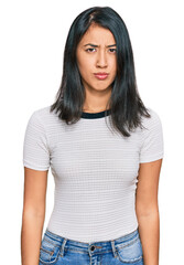 Fototapeta premium Beautiful asian young woman wearing casual white t shirt skeptic and nervous, frowning upset because of problem. negative person.