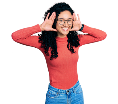 Young hispanic woman with curly hair wearing glasses smiling cheerful playing peek a boo with hands showing face. surprised and exited