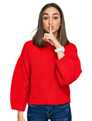 Beautiful brunette woman wearing casual winter sweater asking to be quiet with finger on lips....