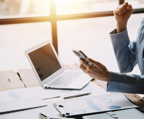 Happy excited successful business asian woman triumphing in office, Portrait of a cheerful Asian businesswoman sitting at the table in office,