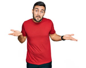 Young hispanic man wearing casual clothes clueless and confused expression with arms and hands raised. doubt concept.