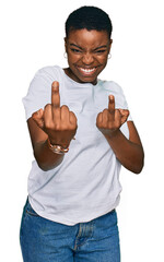 Young african american woman wearing casual white t shirt showing middle finger doing fuck you bad...