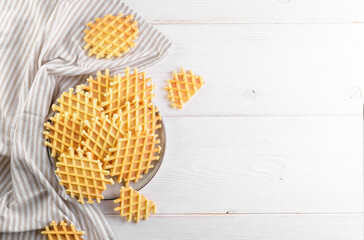 Ferratelle or pizzelle a traditional dessert or cookies on a plate on a white wooden background,...
