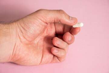 Mano sosteniendo píldora de color blanco - Hand holding white pill