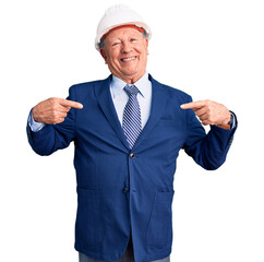 Senior handsome grey-haired man wearing suit and architect hardhat looking confident with smile on face, pointing oneself with fingers proud and happy.