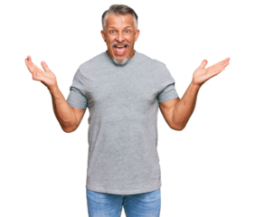 Middle age grey-haired man wearing casual clothes celebrating victory with happy smile and winner expression with raised hands