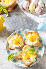 Easter breakfast idea. Scrambled eggs in puff pastry with cheese and bacon on a stone background. Copy space.