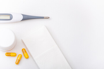 Thermometer, pills, vitamins and tissues on a white background. Home pharmacy