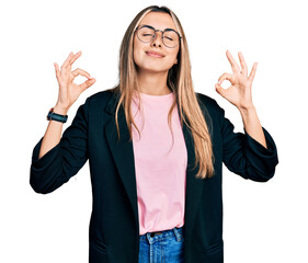 Hispanic young woman wearing business jacket and glasses relaxed and smiling with eyes closed doing meditation gesture with fingers. yoga concept.