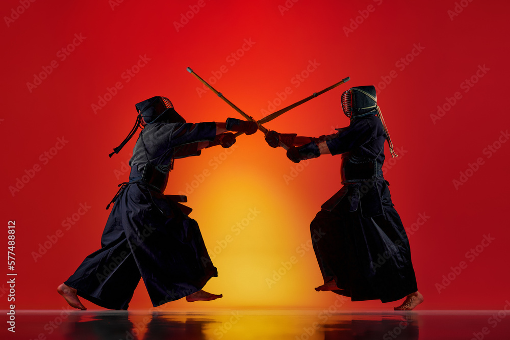 Wall mural dynamic image of two men, professional kendo athletes training with bamboo shinai sword against grad