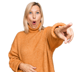 Middle age caucasian woman wearing casual winter sweater pointing with finger surprised ahead, open mouth amazed expression, something on the front