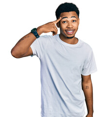 Young african american man wearing casual white t shirt smiling pointing to head with one finger, great idea or thought, good memory