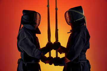 Sword to sword. Two men, professional kendo fighter, athletes in black uniform training against...