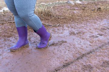 Woman in wellies stepping in the mud