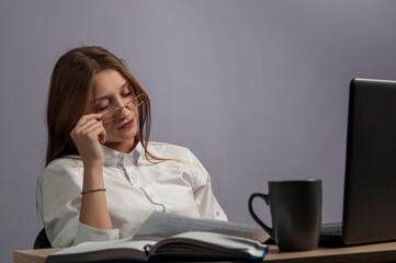 Tired girl at a table with a computer. work and fatigue. The student is sleeping at the table.
