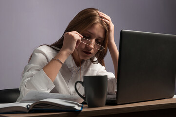 Tired girl at a table with a computer. work and fatigue. The student is sleeping at the table.