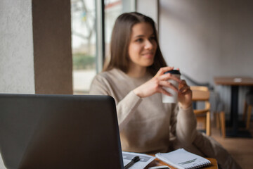 Young women working with laptop while sitting at café 