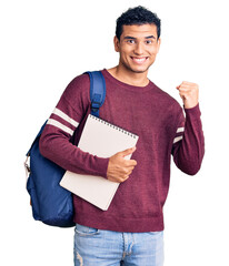 Hispanic handsome young man wearing student backpack and notebook screaming proud, celebrating...