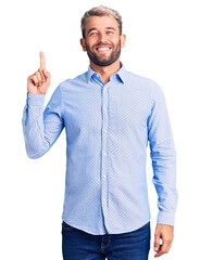 Young handsome blond man wearing elegant shirt showing and pointing up with finger number one while smiling confident and happy.