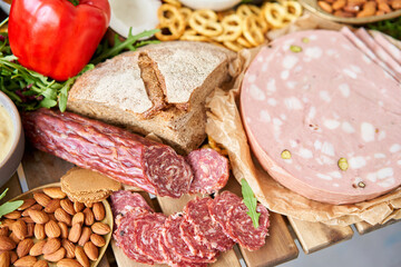 Parma sausage close-up. Table full of mediterranean appetizers, tapas or antipasto. Assorted Italian food set. Delicious snack on party or picnic time. Meat and cheese. Italian style banquet. 