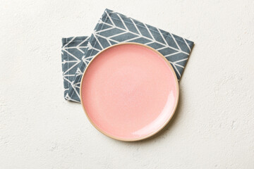 Top view on colored background empty round pink plate on tablecloth for food. Empty dish on napkin with space for your design