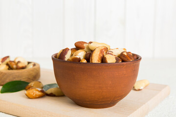 Fresh healthy Brazil nuts in bowl on colored table background. Top view Healthy eating bertholletia concept. Super foods