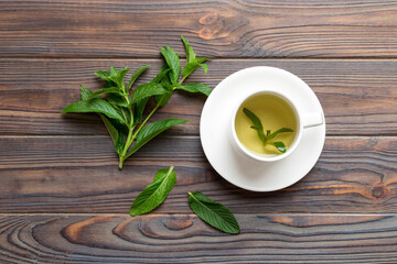 Cup of mint tea on table background. Green tea with fresh mint top view with copy space